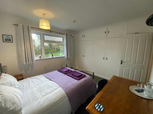 1 dormitorio con cama, mesa y ventana en Agapanthus Bed & Breakfast - Fraddam en Hayle