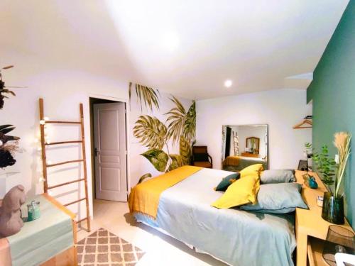 Schlafzimmer mit einem Bett mit gelben und blauen Kissen in der Unterkunft Gîte de la Petite vallée in Saint-Savinien
