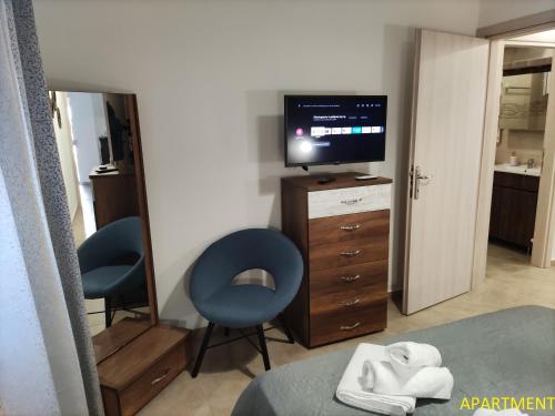 una camera da letto con due sedie e una televisione su un comò di Ηλιοκαλλη - ILIOKALLI a Néa Péramos