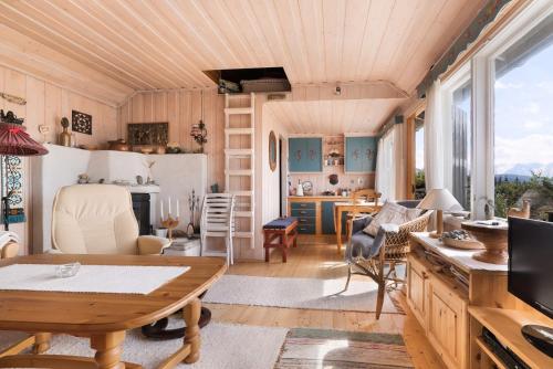 a living room with a wooden ceiling at Koselig og usjenert hytte med fantastisk utsikt og solforhold 