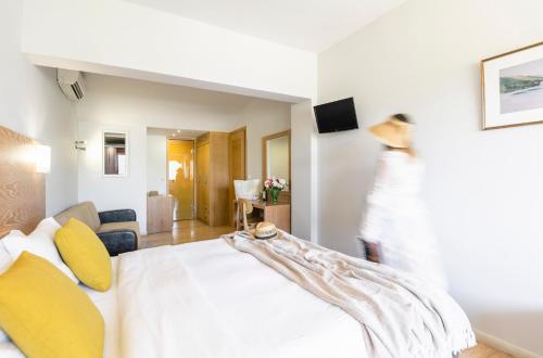 a bedroom with a white bed with yellow pillows at Hotel Lefkas in Lefkada Town