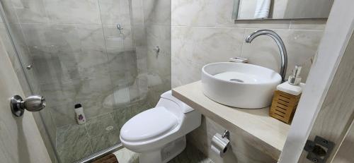 ein Bad mit einem WC, einem Waschbecken und einer Dusche in der Unterkunft Genial apartamento de playa! coveñas in Coveñas