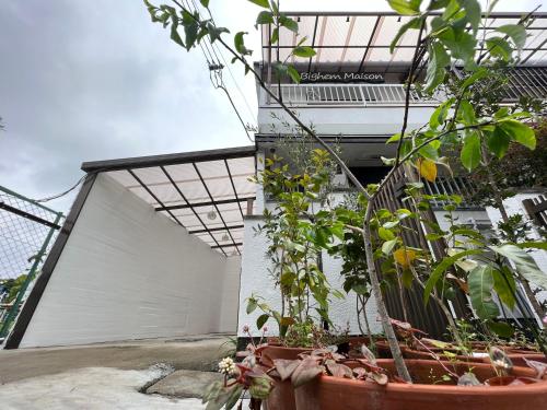 a group of plants in pots in front of a building at Bighem Maison 2 in Izumi-Sano