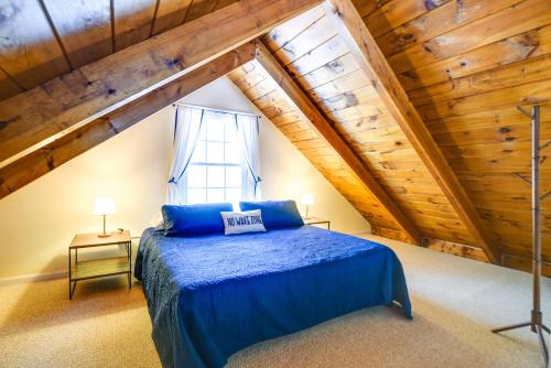 1 dormitorio con 1 cama azul en el ático en Cozy Tuftonboro Home with Deck - Walk to Beaches! 