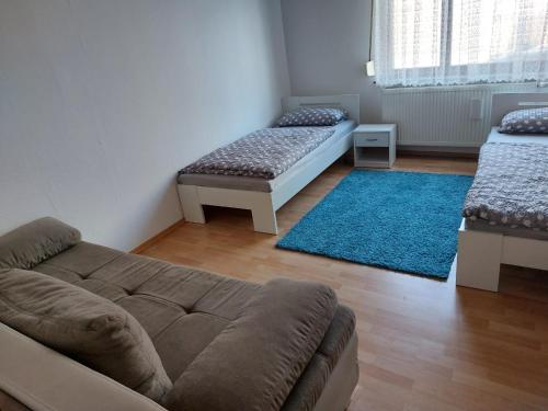 a living room with a couch and a blue rug at Ferienwohnung Enz in Eutingen