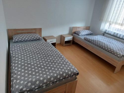 two twin beds in a room with wooden floors at Ferienwohnung Enz 