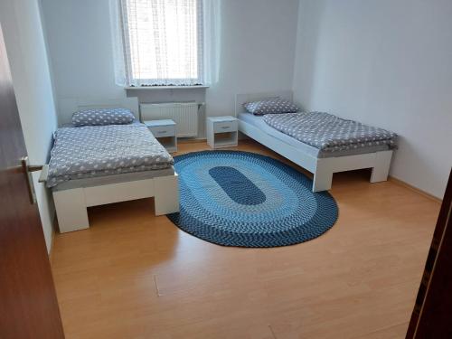 two beds in a room with a rug on the floor at Ferienwohnung Enz 
