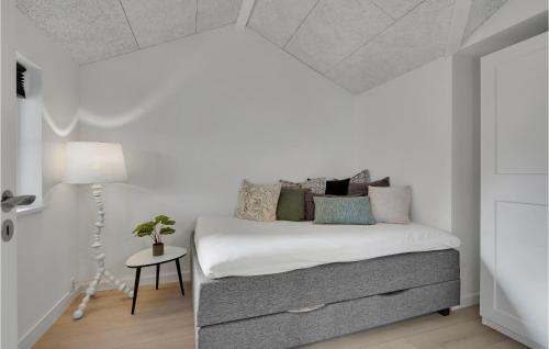 a white bedroom with a bed and a lamp at Beautiful Home In Nyborg With Wifi And 3 Bedrooms in Nyborg