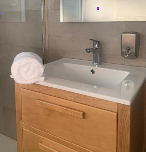 a bathroom sink with a towel on top of it at LA LÍNEA DEL MAR in Trasierra