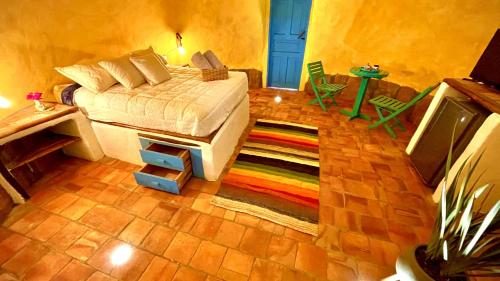 1 dormitorio con cama y alfombra colorida en Hermoso Glamping Creta, en Barichara