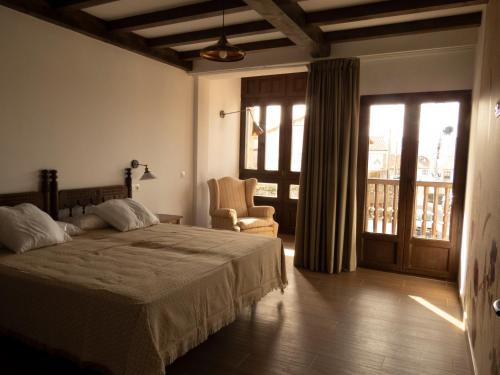 a bedroom with a bed and a chair and a window at LA LÍNEA DEL MAR in Trasierra