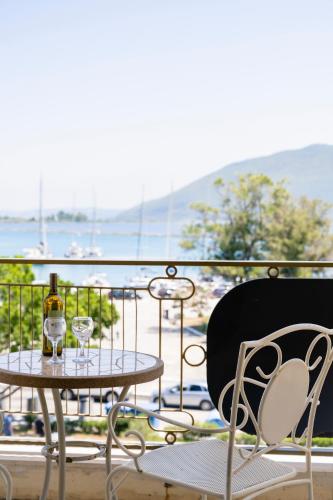 a balcony with a table and two glasses of wine at Hotel Lefkas in Lefkada Town
