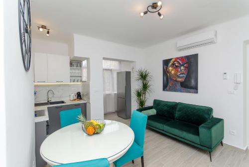 ein Wohnzimmer mit einem grünen Sofa und einem Tisch in der Unterkunft Blue moon Split Apartment in Split