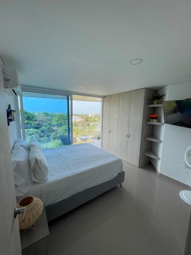 a bedroom with a bed and a large window at Infinity Blue - Playa Dormida in Santa Marta