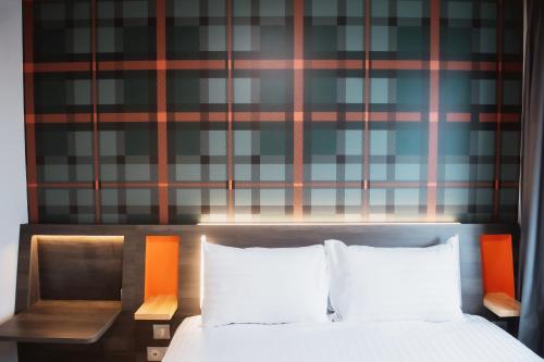 a bed with two white pillows and a wall at easyHotel Paris Nord Aubervilliers in Aubervilliers