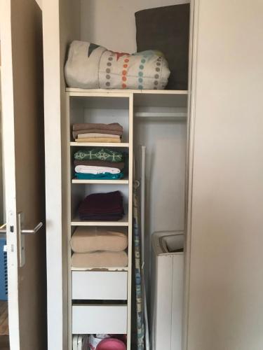 a closet filled with towels and a refrigerator at Joli T1 classe 2* avec balcon proche plages in Saint-Gilles les Bains