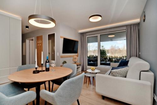 a living room with a table and chairs at BlueApart Apartamenty Na Klifie in Władysławowo