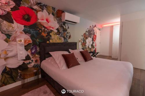 a bedroom with a bed with a floral wall at Touraco in Villars-les-Dombes