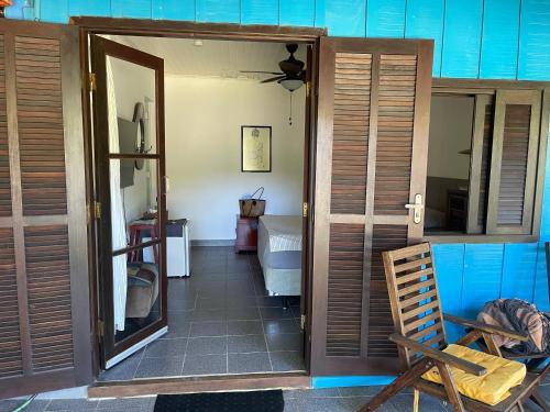 a room with a door and a room with a chair at Casa da Ilha do Mel - Pousada de Charme in Ilha do Mel
