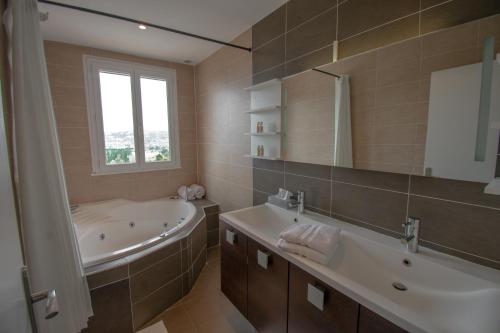 法揚斯的住宿－Maison Fesch, vue panoramique, 120m2, Piscine, 3ch，带浴缸、水槽和镜子的浴室