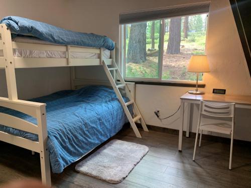 um quarto com beliches, uma secretária e uma janela em A Cozy Cabin Steps From Mountain Trails And Hiking em Mevers