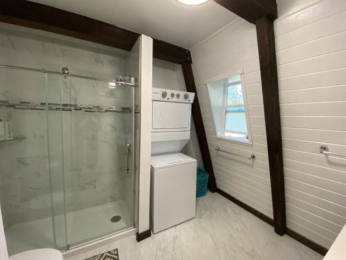 uma casa de banho com um chuveiro e uma cabina de duche em vidro. em A Cozy Cabin Steps From Mountain Trails And Hiking em Mevers