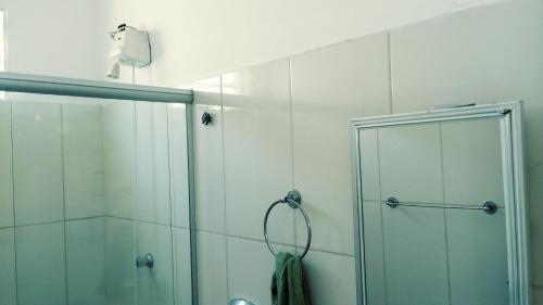 um chuveiro com uma porta de vidro na casa de banho em Parque Mãe Bonifácia-Sobrado 4 suítes com ar e piscina em Cuiabá