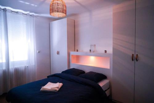 une chambre avec un lit avec une couverture bleue dans l'établissement Le Straw' Berry • Fibre • Calme, à Châteauroux