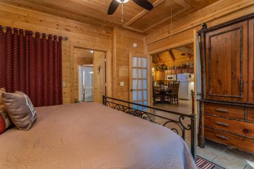 a bedroom in a log cabin with a bed and a dining room at Ole Hickory w/Firepit HotTub in Ridgedale