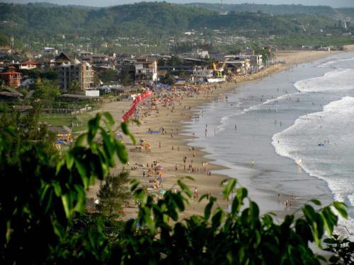a group of people on a beach near the ocean at Casa del Sol in Montañita