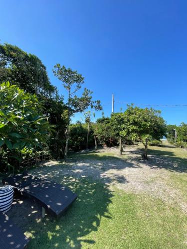 a park with a bench in the grass at Casa da Ilha do Mel - Pousada de Charme in Ilha do Mel
