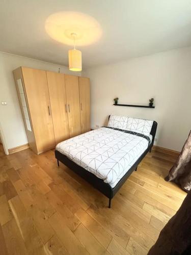 Schlafzimmer mit einem Bett und Holzboden in der Unterkunft Beautiful 2 bedroom garden flat w/ free parking in Surbiton