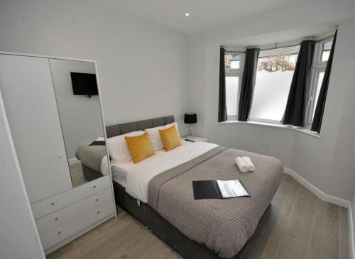 a bedroom with a large bed and a mirror at Walton Suites in Watford