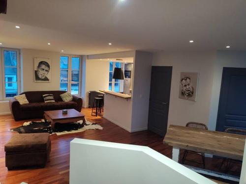 een woonkamer met een bank en een tafel bij Duplex, Le Citadin in Cherbourg en Cotentin