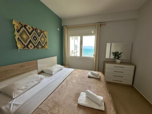 een slaapkamer met een groot bed en een raam bij TreA Accomodations - On Private Beach with sunbed & umbrella in Vlorë