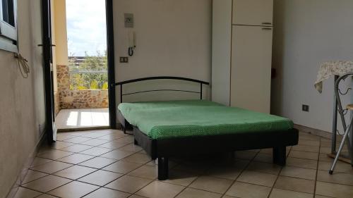 ein kleines Bett in einem Zimmer mit Fenster in der Unterkunft Casa Vacanze Mari Pintau in Geremèas