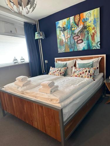 Apartment Fleurette في زاندفورت: سرير كبير في غرفة نوم مع لوحة على الحائط