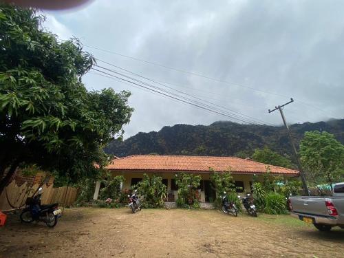 a house with motorcycles parked in front of it at Letana Guesthouse in Ban O