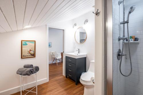 a bathroom with a shower and a sink and a toilet at The Surf Hale - Sleeps 4 - Elevated Surf Aesthetic in Kahuku