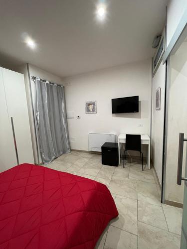 ウッジャーノ・ラ・キエーザにあるB&B Quintadecimaのベッドルーム(赤いベッド1台、デスク付)