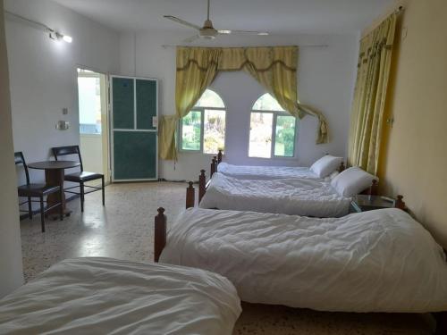 a bedroom with two beds and a table and chairs at Pella Countryside hotel 