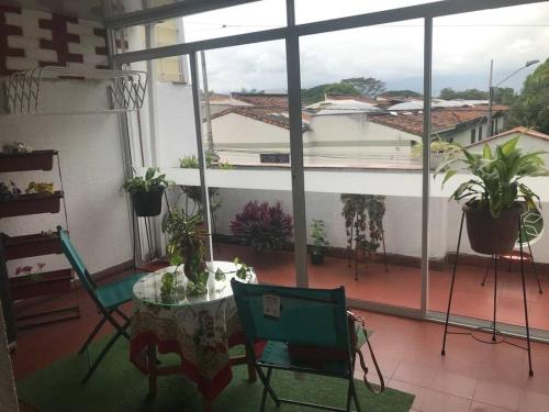 a balcony with a table and chairs and potted plants at CASA ACOGEDORA ACORDE A TU ESTILO in Palmira