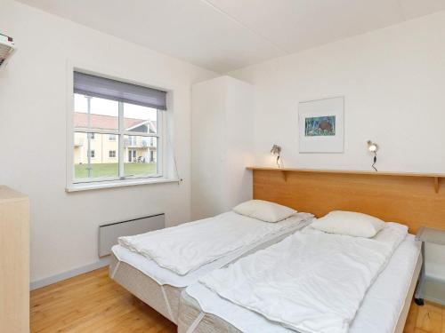 a white bedroom with a large bed with a window at Apartment Hals V in Hals
