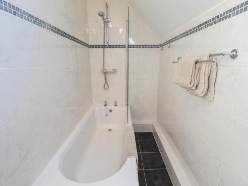 ein weißes Bad mit einer Badewanne und einer Dusche in der Unterkunft The Granary in Louth