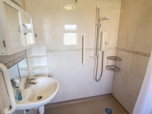W łazience znajduje się umywalka i prysznic. w obiekcie Nursery Cottage w mieście Louth