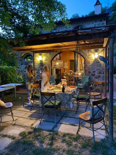 two women standing in a patio with a table and chairs at Il Borghetto Andrea Tafi in Lamporecchio