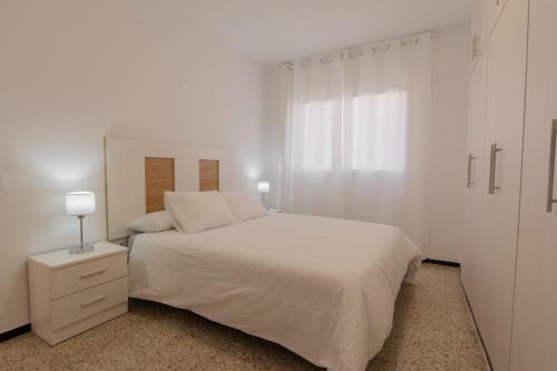 a white bedroom with a white bed and a window at Tendal Hosting - Cabrera Guerra in Santa Cruz de la Palma