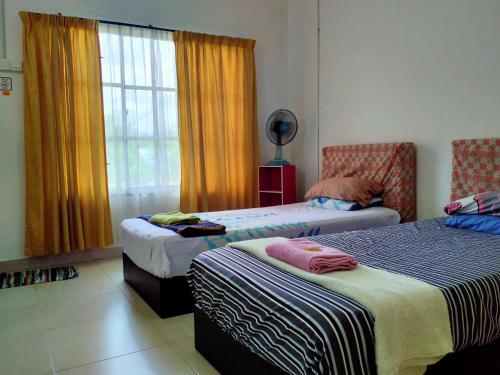 a bedroom with two beds and a window at MELATI INN in Kajang