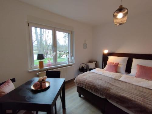 Schlafzimmer mit einem Bett, einem Tisch und einem Fenster in der Unterkunft Ferienwohnung Fuchsbau Jüterbog in Jüterbog