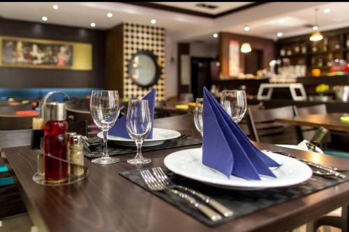 a table with plates and wine glasses and napkins at Hotel Swiss Holiday in Budva